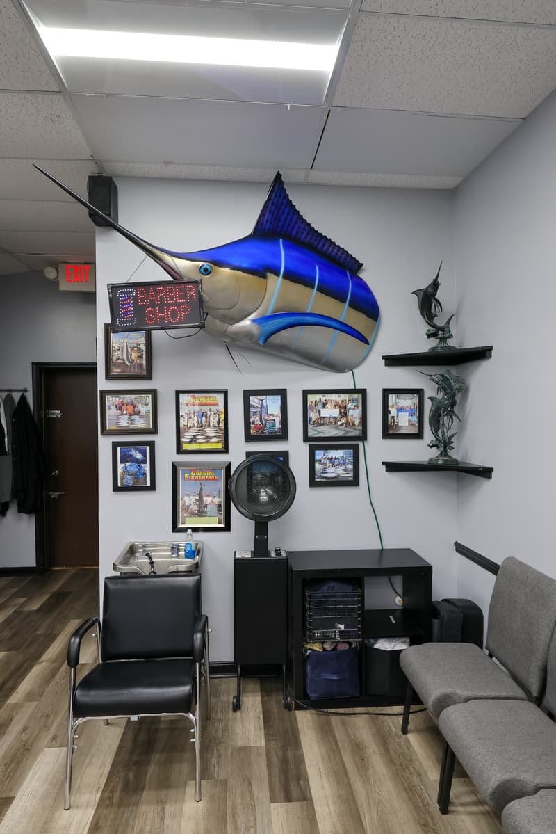 Marlin trophy and lit barber shop sign inside Olde Tyme Family Barber Shop