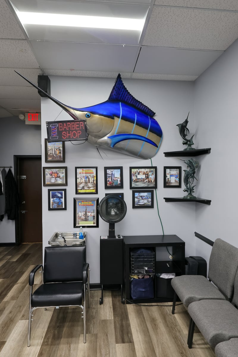 Marlin trophy and lit barber shop sign inside Olde Tyme Family Barber Shop